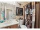 This bathroom includes a single sink vanity, toilet, decorative curtain, and an ornate mirror at 2309 W Firethorn Way, Anthem, AZ 85086