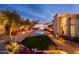 Expansive backyard featuring a well-manicured lawn, sparkling pool, lush greenery, and charming outdoor seating areas at 2548 E Vermont Ave, Phoenix, AZ 85016