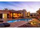 Stunning backyard showcasing a sparkling pool, a covered seating area with a fire pit, and beautiful landscaping at 2548 E Vermont Ave, Phoenix, AZ 85016