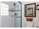 Bathroom featuring a glass shower door, white subway tile, small accent tiles, and a framed mirror above the toilet at 2548 E Vermont Ave, Phoenix, AZ 85016