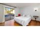 Bright bedroom featuring hardwood floors, white bedding and drapes that look out over the pool and patio at 2548 E Vermont Ave, Phoenix, AZ 85016