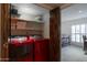 Modern laundry room featuring red washer and dryer, built-in shelves, and easy access to the bedroom at 2548 E Vermont Ave, Phoenix, AZ 85016