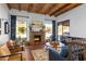 Inviting living room with a stone fireplace, wood beam ceilings, hardwood floors, and comfortable seating at 2548 E Vermont Ave, Phoenix, AZ 85016
