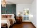 This main bedroom has a luxurious and peaceful vibe with its hardwood floors and unique turquoise headboard at 2548 E Vermont Ave, Phoenix, AZ 85016