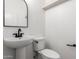 Stylish powder room with pedestal sink, matte black fixtures, and arched mirror at 2789 S Balsam Dr, Gilbert, AZ 85295