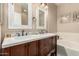 Bathroom featuring double vanity sinks, dark cabinetry and soaker tub at 2992 N Miller Rd # 219B, Scottsdale, AZ 85251