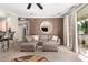 Living room with stylish sectional couch, round mirror, and sliding door to the outdoors at 2992 N Miller Rd # 219B, Scottsdale, AZ 85251