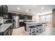 Modern kitchen with dark cabinets, granite countertops, stainless steel appliances, and breakfast bar seating at 30324 W Crittenden Ln, Buckeye, AZ 85396