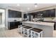 Kitchen with granite countertops, dark cabinets, stainless appliances, and island seating at 30324 W Crittenden Ln, Buckeye, AZ 85396