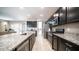 A kitchen showcasing an island with granite countertop, stainless steel appliances, and dark cabinets at 30324 W Crittenden Ln, Buckeye, AZ 85396