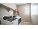 Laundry room showcasing front-load washer and dryer with built-in shelving at 30324 W Crittenden Ln, Buckeye, AZ 85396