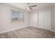 Spacious bedroom features new gray floors, a ceiling fan and ample closet space at 3120 N 67Th Ln # 96, Phoenix, AZ 85033