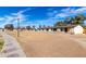 A street view shows a community of homes with desert landscaping and mature trees on a sunny day at 3120 N 67Th Ln # 96, Phoenix, AZ 85033