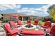 A beautifully designed backyard features a fire pit, patio, outdoor bar and dining space with well-manicured artificial lawn at 31626 N 129Th Dr, Peoria, AZ 85383