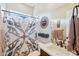 Neutral bathroom featuring decorative shower curtain and wall art at 31626 N 129Th Dr, Peoria, AZ 85383