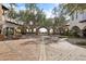 Open-air courtyard with manicured trees, brick pathway, and view to an arched entryway at 31626 N 129Th Dr, Peoria, AZ 85383