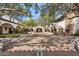 Expansive courtyard with brick paving, arched walkways, and mature trees creating a serene atmosphere at 31626 N 129Th Dr, Peoria, AZ 85383