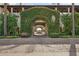 Grand entrance to courtyard with lush green vines, stone path, and decorative trees at 31626 N 129Th Dr, Peoria, AZ 85383
