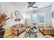 Cozy living room with comfortable seating, a ceiling fan, and ample natural light at 31626 N 129Th Dr, Peoria, AZ 85383