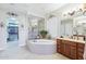 Bright main bathroom with a jacuzzi tub, a glass walk-in shower, and double vanities at 31626 N 129Th Dr, Peoria, AZ 85383