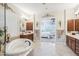 Bright main bathroom with a jacuzzi tub, double vanities, and access to the main bedroom at 31626 N 129Th Dr, Peoria, AZ 85383