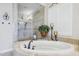 Bright main bathroom with a jacuzzi tub and a glass walk-in shower with dual shower heads at 31626 N 129Th Dr, Peoria, AZ 85383