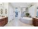 Bright main bathroom with a jacuzzi tub, a glass walk-in shower, and double vanities at 31626 N 129Th Dr, Peoria, AZ 85383