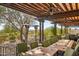 Spacious outdoor patio with a wooden pergola, multiple seating areas, and scenic views at 31626 N 129Th Dr, Peoria, AZ 85383