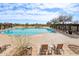 Large outdoor pool surrounded by lounging chairs, lush landscaping, and blue skies at 31626 N 129Th Dr, Peoria, AZ 85383