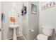 This bathroom features a pedestal sink, oval mirror and whimsical beach-themed decorations at 32405 N 23Rd Ave, Phoenix, AZ 85085