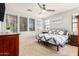Bright bedroom with a ceiling fan, three large windows, and a bed with a blue and white quilt at 32405 N 23Rd Ave, Phoenix, AZ 85085