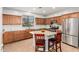 Well-lit kitchen featuring an island with seating, stainless steel appliances, and tile backsplash at 32405 N 23Rd Ave, Phoenix, AZ 85085