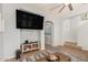 Cozy living room with a large wall-mounted TV, ceiling fan, and neutral decor at 32405 N 23Rd Ave, Phoenix, AZ 85085