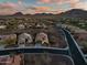 Serene aerial view of desert community surrounded by mountains under a colorful sunset sky at 3318 W Ravina Ln, Anthem, AZ 85086