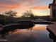 Picturesque pool and spa area at sunset, reflecting the colorful sky at 3318 W Ravina Ln, Anthem, AZ 85086