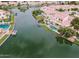 A bird's eye view of a community with waterfront homes, private pools, and boat docks on a scenic lake at 3370 S Ivy Way, Chandler, AZ 85248