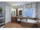 A primary bathroom with a vanity area, soaking tub with a mosaic tile surround, and decorative wall paper at 3370 S Ivy Way, Chandler, AZ 85248
