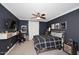 A dark and cozy bedroom featuring a ceiling fan, mounted TV, and neutral-colored carpet at 3370 S Ivy Way, Chandler, AZ 85248