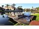 Docked pontoon boat, lakeside with waterfront home in the background and lush landscaping at 3370 S Ivy Way, Chandler, AZ 85248