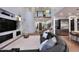 Open-concept living room with dark leather sectional, fireplace, high ceilings, and a staircase at 3370 S Ivy Way, Chandler, AZ 85248