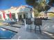 A covered outdoor kitchen and bar area provide a luxurious space for cooking and entertaining near the pool at 3370 S Ivy Way, Chandler, AZ 85248