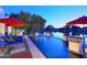 A backyard pool overlooking the lake at dusk, featuring fountains, lounge chairs, umbrellas and an outdoor bar at 3370 S Ivy Way, Chandler, AZ 85248