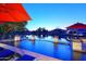 Lakeside pool at dusk featuring fountains and lounge chairs with umbrellas at 3370 S Ivy Way, Chandler, AZ 85248