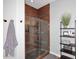 A glass door shower with brown tile and decorative trim, includes wall-mounted shower head and matte black hardware at 3370 S Ivy Way, Chandler, AZ 85248