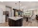 Bright kitchen featuring white cabinets and a dark stained center island with quartz countertops at 35212 N Magnette Way, San Tan Valley, AZ 85144