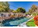 A luxurious pool with waterfall features and relaxing lounge chairs amidst a beautiful, private backyard oasis at 3647 E Elm St, Phoenix, AZ 85018