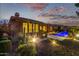 Beautiful home featuring a built-in grill and bar adjacent to a pool with bright illumination and a wonderful night view at 3654 E San Pedro Pl, Chandler, AZ 85249