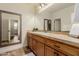 Bright bathroom features wood cabinets, tile countertop, decorative mirror, and neutral tones at 3654 E San Pedro Pl, Chandler, AZ 85249
