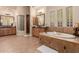 Luxurious bathroom featuring a soaking tub, glass block details, dual vanities, and elegant fixtures at 3654 E San Pedro Pl, Chandler, AZ 85249