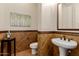 Stylish powder room with brown tile, a pedestal sink, accent wall, and decorative wall art at 3654 E San Pedro Pl, Chandler, AZ 85249